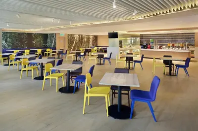 a cafeteria filled with tables and chairs and a kitchen at Holiday Inn Express Kuala Lumpur City Centre by IHG in Kuala Lumpur