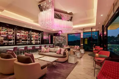 a bar with couches and tables and a chandelier at The St. Regis Kuala Lumpur in Kuala Lumpur