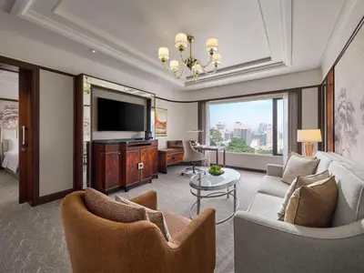 a living room with a couch and a television at Shangri-La Kuala Lumpur in Kuala Lumpur