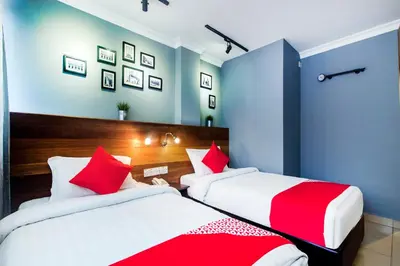 two beds in a room with blue and red at OYO 761 City Hotel in Kuala Lumpur