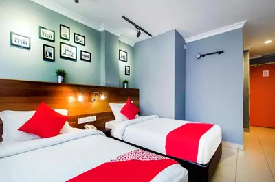 two beds in a room with red and white at OYO 761 City Hotel in Kuala Lumpur
