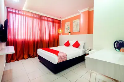 a hotel room with a bed and red curtains at OYO 761 City Hotel in Kuala Lumpur