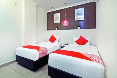 two beds in a room with red and white at OYO 761 City Hotel in Kuala Lumpur
