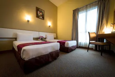 a hotel room with two beds and a window at Hotel Sentral Kuala Lumpur at KL Sentral Station in Kuala Lumpur
