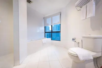 a white bathroom with a toilet and a window at Hotel Sentral Kuala Lumpur at KL Sentral Station in Kuala Lumpur