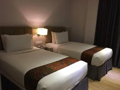 a hotel room with two beds and a lamp at NU Hotel @ KL Sentral in Kuala Lumpur