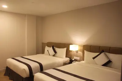 a hotel room with two beds and two lamps at NU Hotel @ KL Sentral in Kuala Lumpur