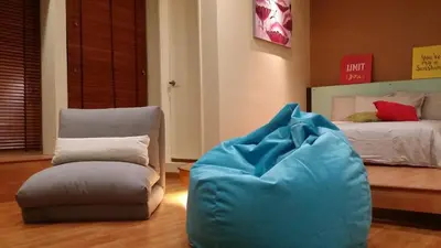 a room with a chair and a bed with a blue pillow at Parkview KLCC Serviced Suites in Kuala Lumpur