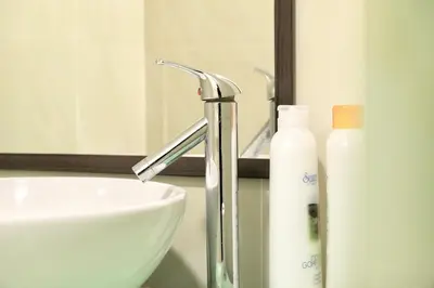 a bathroom with a sink and a faucet and a mirror at Parkview KLCC Serviced Suites in Kuala Lumpur