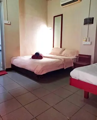 a bedroom with two beds and a mirror on the wall at Birdnest Guesthouse, Gaia Rooftop Cafe in Kuala Lumpur