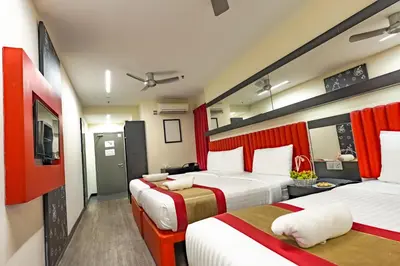 a hotel room with two beds and a television at Lazdana Hotel Kuala Lumpur in Kuala Lumpur