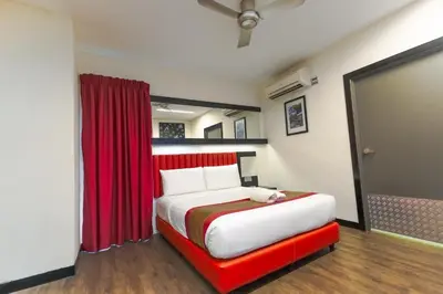 a bedroom with a large bed with a red curtain at Lazdana Hotel Kuala Lumpur in Kuala Lumpur