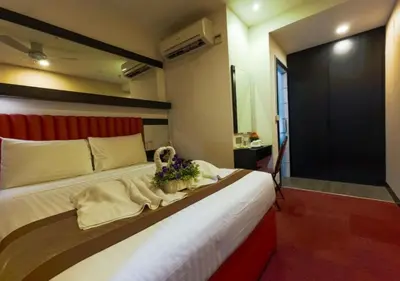 a bedroom with a large bed with flowers on it at Lazdana Hotel Kuala Lumpur in Kuala Lumpur