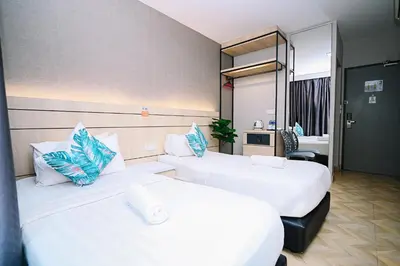 a hotel room with two beds and a mirror at Kingston Hotel 2 - Setapak in Kuala Lumpur