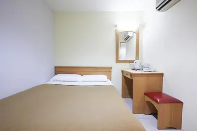 a small bedroom with a bed and a mirror at Tang City Hotel, Petaling Street, Merdeka PNB 118 Tower in Kuala Lumpur