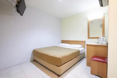 a small bedroom with a bed and a mirror at Tang City Hotel, Petaling Street, Merdeka PNB 118 Tower in Kuala Lumpur