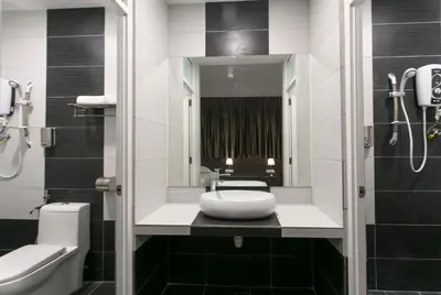 a bathroom with a sink and a toilet and a mirror at Lavana Hotel, Chinatown in Kuala Lumpur