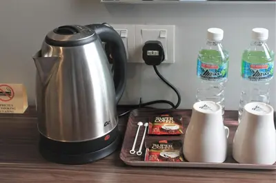 a coffee maker sitting on top of a table next to water bottles at Lavana Hotel, Chinatown in Kuala Lumpur