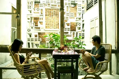 a man and woman sitting in chairs at a table at Chinatown Hostel by Mingle - Rooftop Private Jacuzzi with Bar in Kuala Lumpur