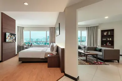 a bedroom with a bed and a living room at Oakwood Hotel & Residence Kuala Lumpur in Kuala Lumpur
