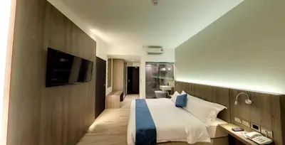 a hotel room with a bed and a television at Flora by Crossroads Hotel in Kuala Lumpur