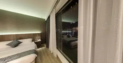 a hotel room with a large window with a bedroom at Flora by Crossroads Hotel in Kuala Lumpur