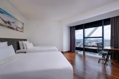 a hotel room with two beds and a desk and a window at Element Kuala Lumpur in Kuala Lumpur