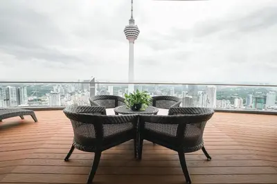 a balcony with a table and chairs on a roof at The Penthouse KLCC in Kuala Lumpur