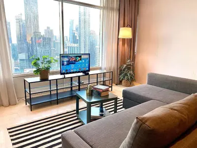 a living room with a couch and a television on a table at Stella Maison KLCC in Kuala Lumpur