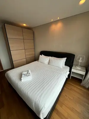 a bedroom with a large bed with a white purse on it at Stella Maison KLCC in Kuala Lumpur
