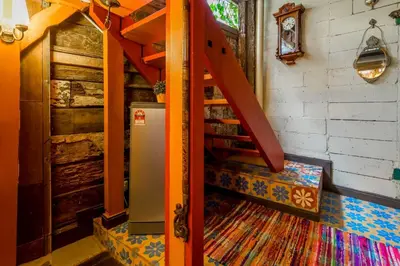 an orange staircase in a room with a refrigerator at Classic Malay House in KL City Centre in Kuala Lumpur