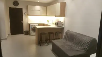 a kitchen with a counter and stools in a room at Parkview Service Apartments in Kuala Lumpur