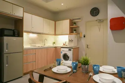a kitchen with a wooden table with plates on it at Parkview Service Apartments in Kuala Lumpur