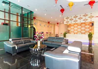 a lobby with couches and flowers in a building at Signature International Hotel China Town in Kuala Lumpur