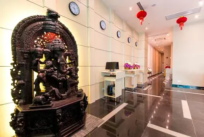 a statue in a lobby with a clock on the wall at Signature International Hotel China Town in Kuala Lumpur
