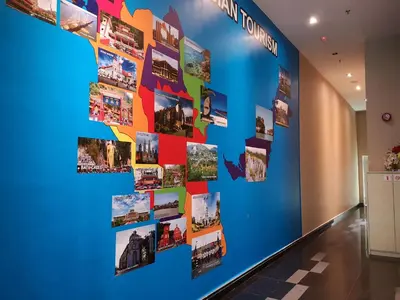 a wall with photos on it in a hallway at Signature International Hotel China Town in Kuala Lumpur