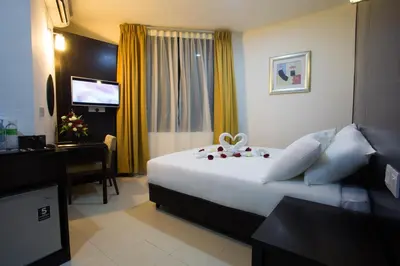 a hotel room with a bed and a desk and a television at Akar Hotel Jalan TAR in Kuala Lumpur