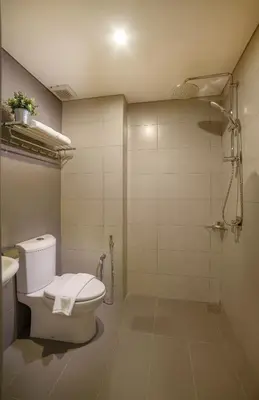 a bathroom with a white toilet and a shower at Riccarton Capsule Hotel in Kuala Lumpur