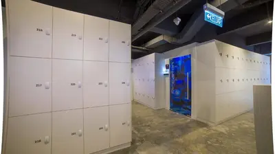 a locker room with white cabinets and a blue door at Riccarton Capsule Hotel in Kuala Lumpur
