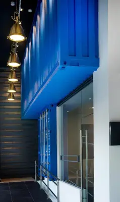 a building with blue walls and lights on the side at Riccarton Capsule Hotel in Kuala Lumpur
