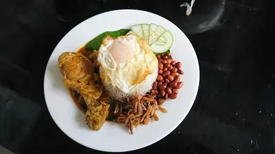 a plate of food with a fried egg and beans at InnB Park Hotel in Kuala Lumpur