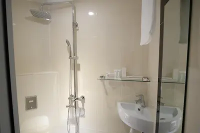 a white bathroom with a shower and a sink at InnB Park Hotel in Kuala Lumpur