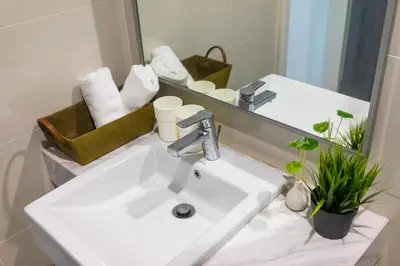 a bathroom with a white sink and a mirror at Five Senses Suite in M Suite KLCC in Kuala Lumpur