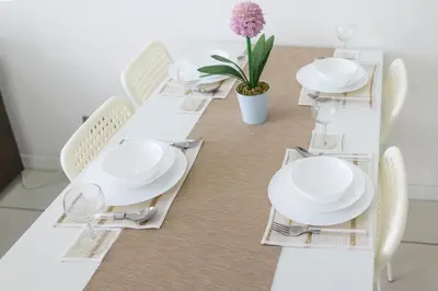 a dining room table with white plates and chairs at Five Senses Suite in M Suite KLCC in Kuala Lumpur