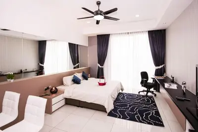 a bedroom with a bed and a desk and chairs at Five Senses Suite in M Suite KLCC in Kuala Lumpur