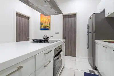 a kitchen with a sink and a refrigerator at Five Senses Suite in M Suite KLCC in Kuala Lumpur