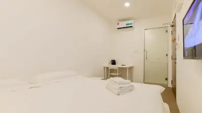 a white bedroom with a bed with towels on it at Fumah Hotel Jalan Kuching in Kuala Lumpur