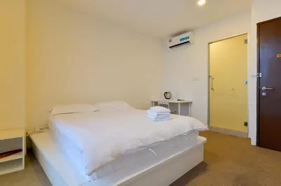 a white bed in a room with a door at Fumah Hotel Jalan Kuching in Kuala Lumpur