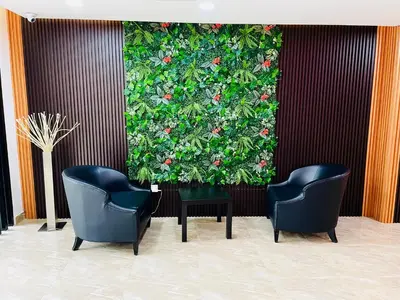 two chairs and a wall with a plant at Cozy Hotel@ KL Sentral in Kuala Lumpur