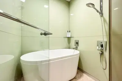 a white bathroom with a shower and a toilet at Soho Suites KLCC by Leala in Kuala Lumpur
